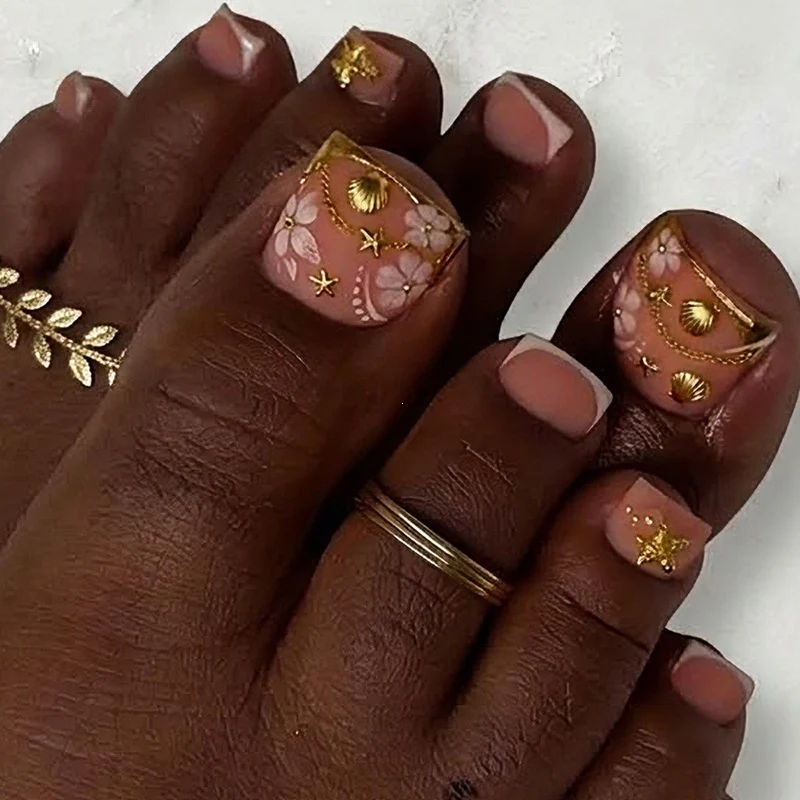 Kunstnagelset mit eleganten, floralen Akzenten und goldenen Verzierungen Karnz