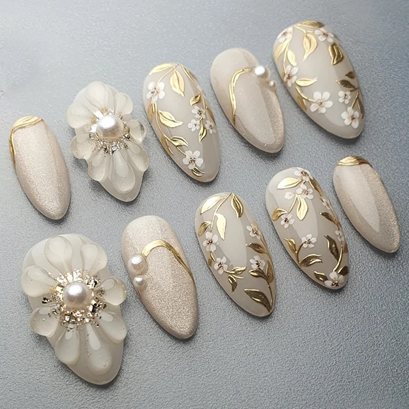 Kunstnagelset mit eleganten Blüten- und Perlenverzierungen Karnz