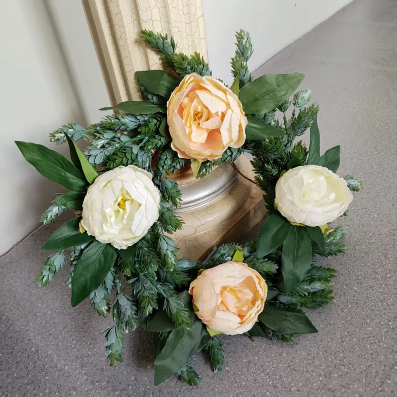 Lebensechter Blumenkranz mit grünen Akzenten