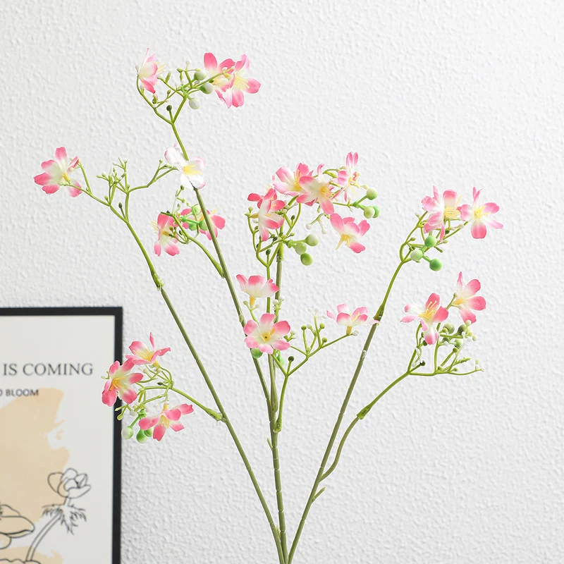Künstlicher Blütenzweig mit zarten blauen Blumen und grünen Beeren Karnz