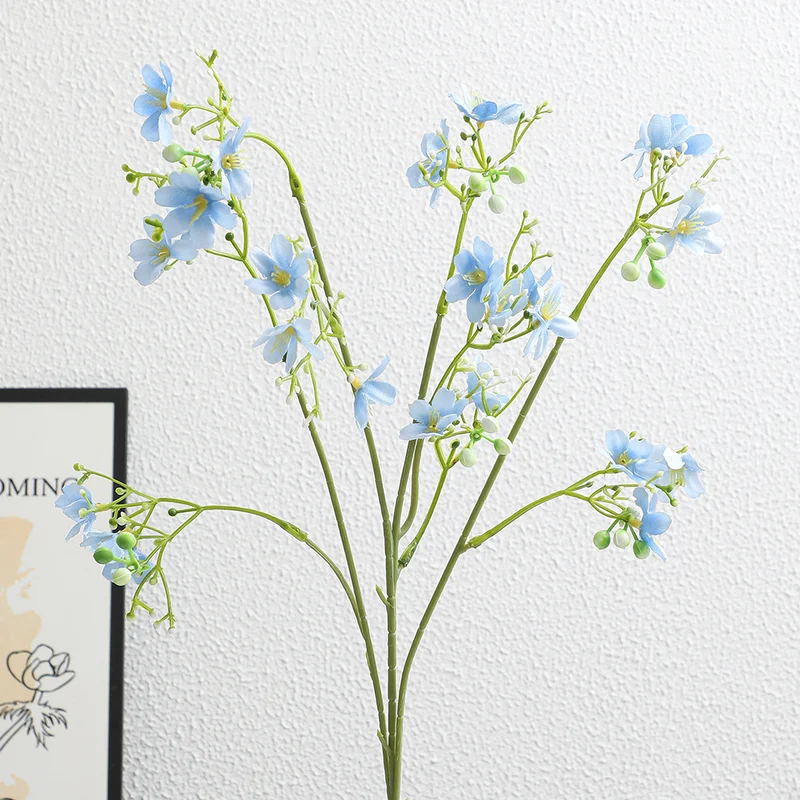 Künstlicher Blütenzweig mit zarten blauen Blumen und grünen Beeren Karnz