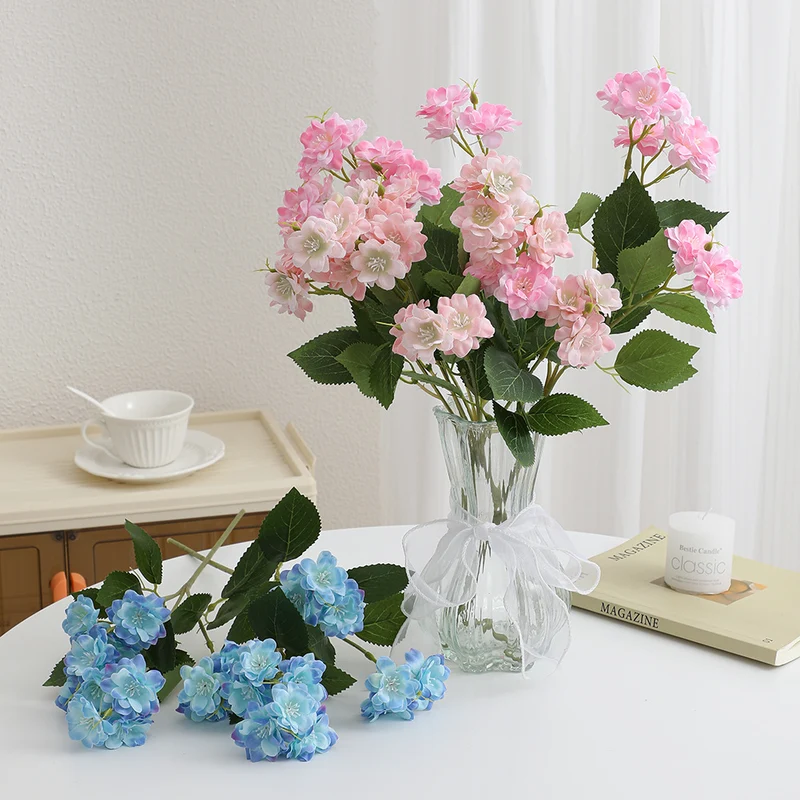 Kunstblumenarrangement mit zarten weißen Blüten Karnz