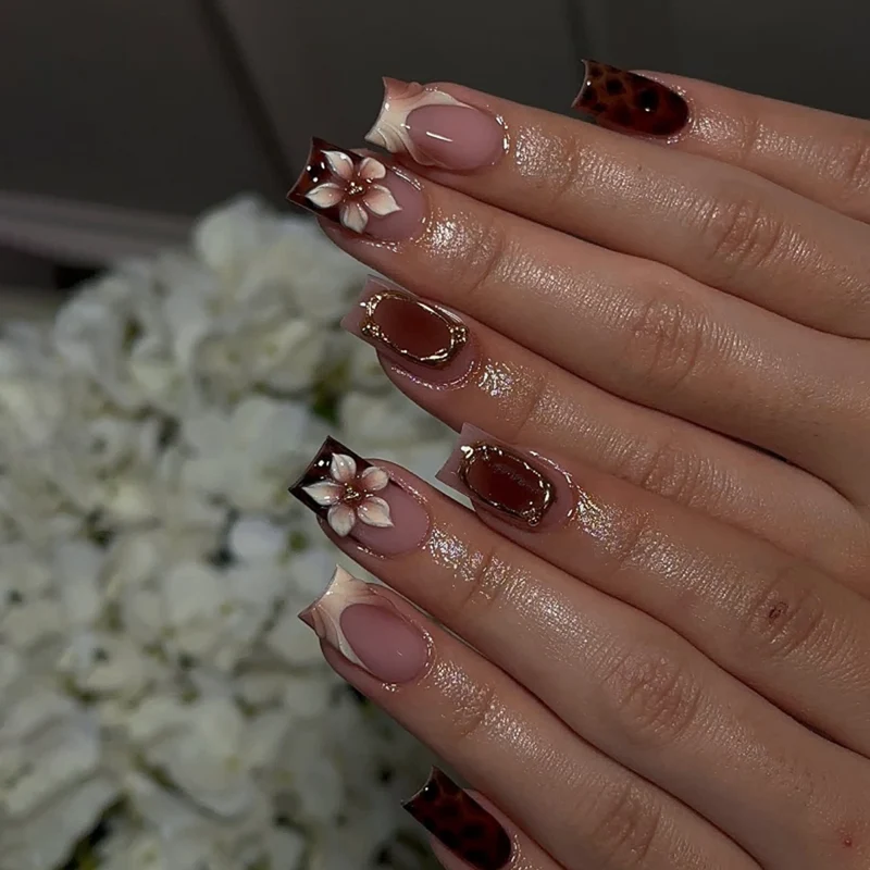 Kunstvolle Stiletto-Nägel mit eleganten Floraldesign und Glitzereffekten Karnz