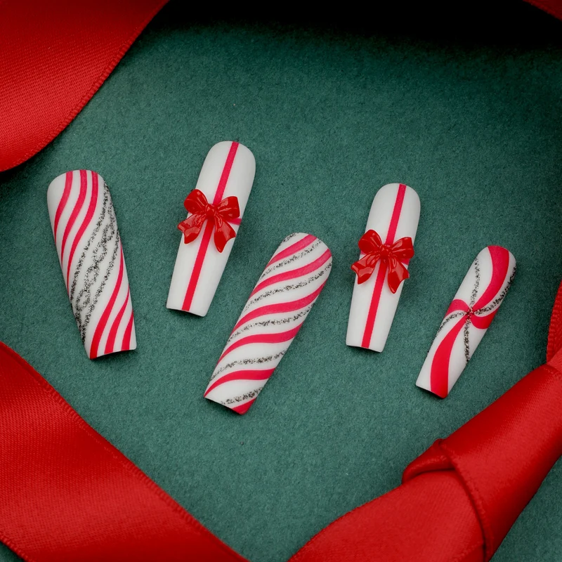 Kunstvolle Nagelkunst mit festlichen Schleifen und Weihnachtsmotiven Karnz