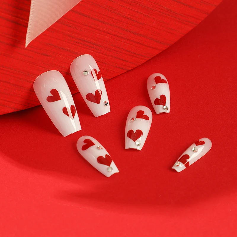 Kunstvolle Nagelverlängerungen mit romantischen Herzmotiven Karnz