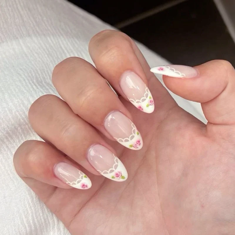 Kunstvolle Nagelkunst mit Blumen-Design und Blauem French Tip Karnz