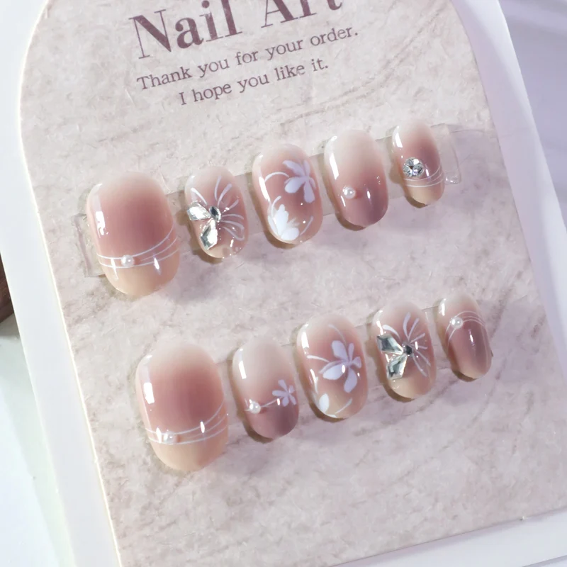 Kunstvolle Nagelgestaltung mit floralem Design und Glitzerakzenten Karnz