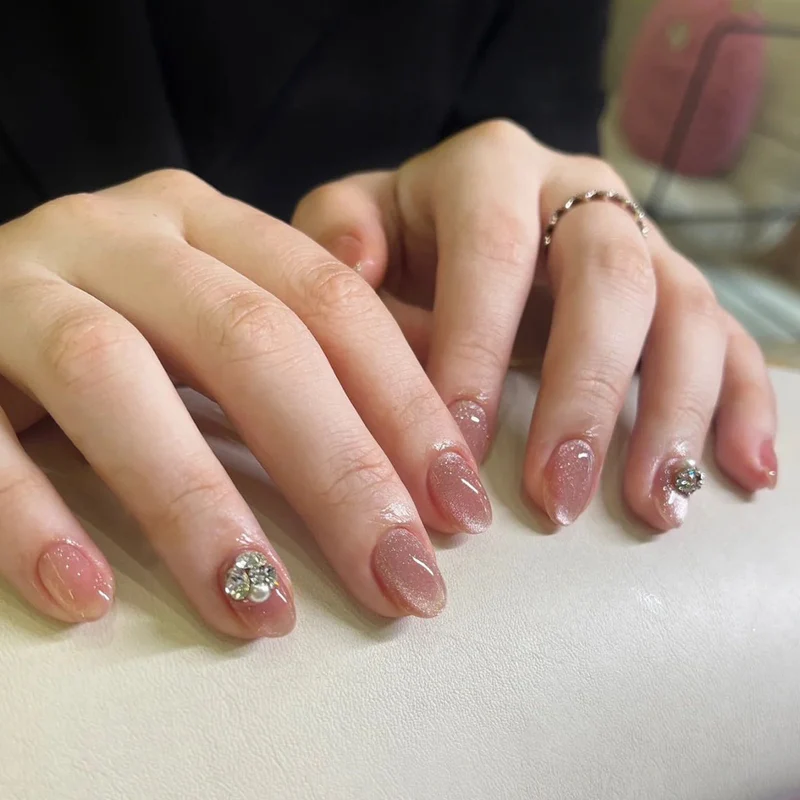 Kunstvolle Glitzer-Nagelverlängerungen mit eleganten Strass-Akzenten Karnz