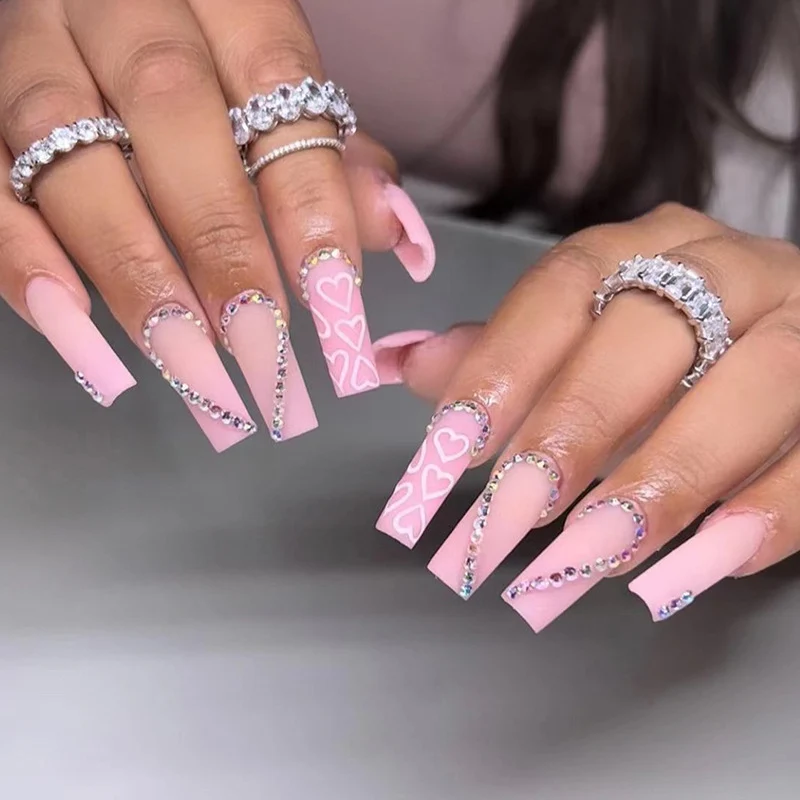 Kunstvolle Gel-Nägel mit elegantem Floral-Design und Glitzerakzenten Karnz