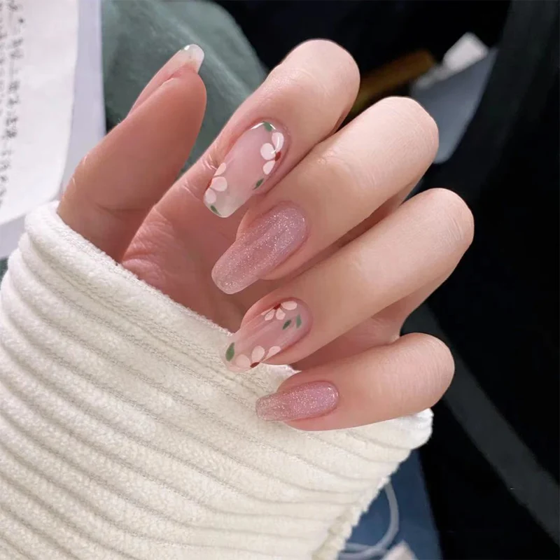 Kunstvolle Gel-Nägel mit elegantem Floral-Design und Glitzerakzenten Karnz