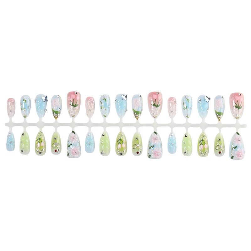 Kreatives Kunstnagelset mit floralen Akzenten und Glitzerverzierungen Karnz