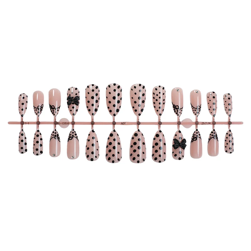 Kreatives Kunstnagelset mit eleganten Punkten und Schleifenverzierungen Karnz