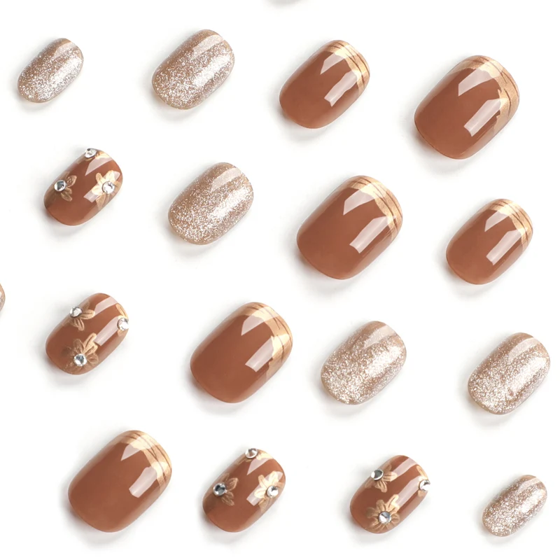 Elegante Nageldekoration mit Glitzer und floralen Akzenten Karnz