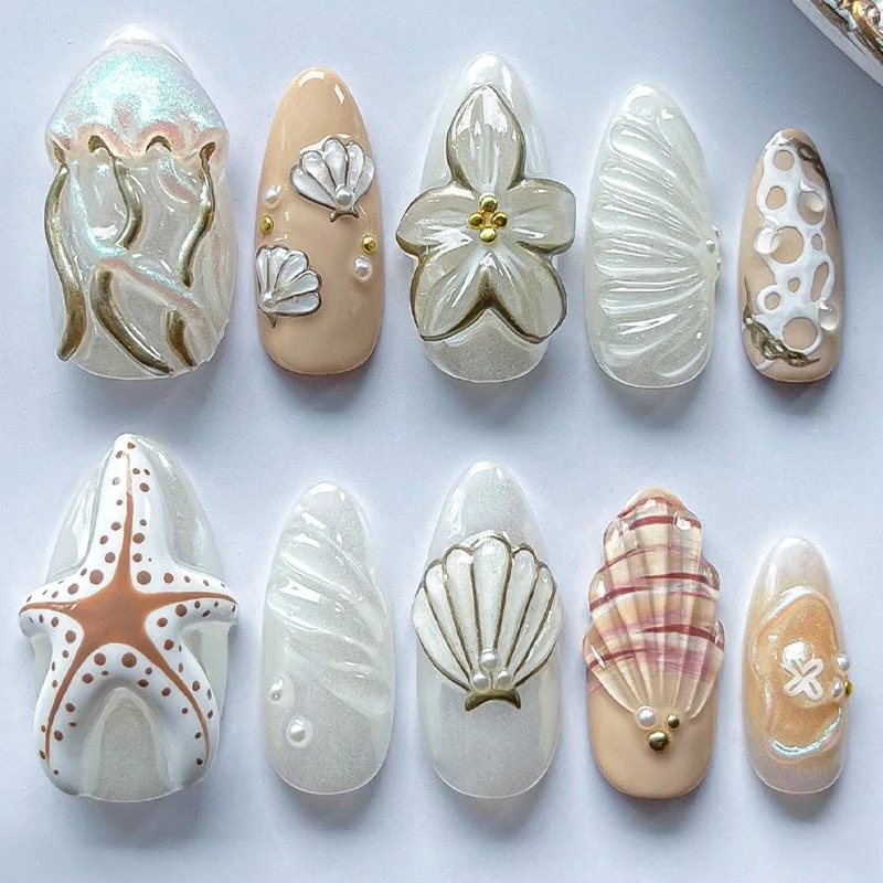 luxuriöses Kunstnagelset mit maritimen Designs und goldenen Akzenten Karnz