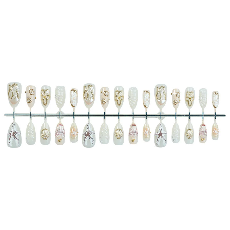 luxuriöses Kunstnagelset mit maritimen Designs und goldenen Akzenten Karnz