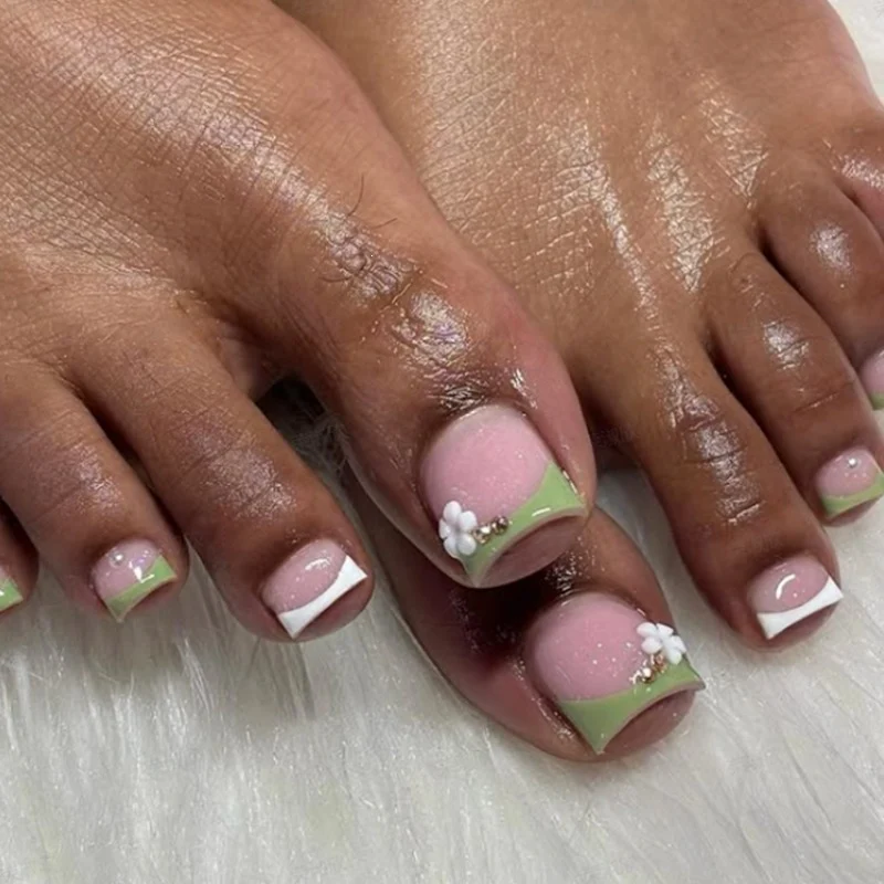 Kunstnagelset mit zarten Blütenmotiven und Glanz Karnz