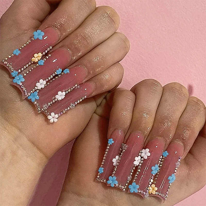 Kunstnagelset mit zarten Blumenverzierungen und Glitzerakzenten Karnz