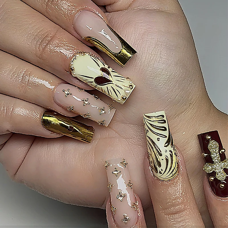 Kunstnagelset mit luxuriösen goldenen Akzenten und funkelnden Verzierungen Karnz