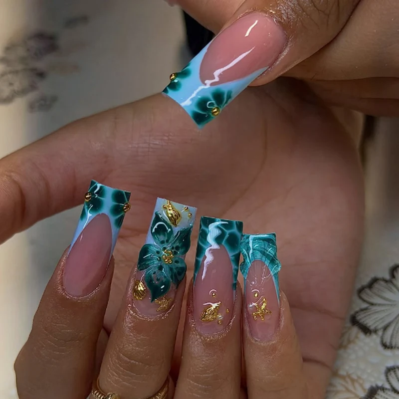 Kunstnagelset mit luxuriösen floralen Akzenten und goldenen Details Karnz