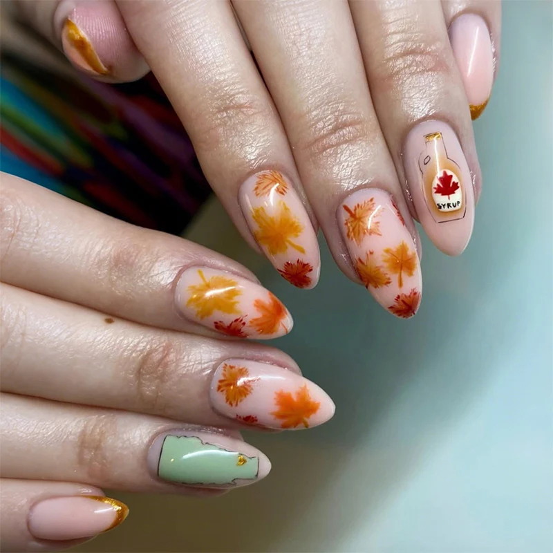 Kunstnagelset mit Herbstblatt-Dekoren und eleganten Farbverläufen Karnz