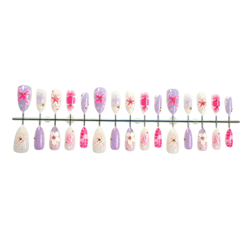 Kunstnagelset mit floralen Verzierungen und zartem Glitzer Karnz