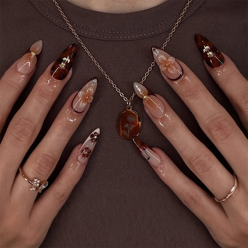 Kunstnagelset mit floralen und glamourösen Verzierungen Karnz