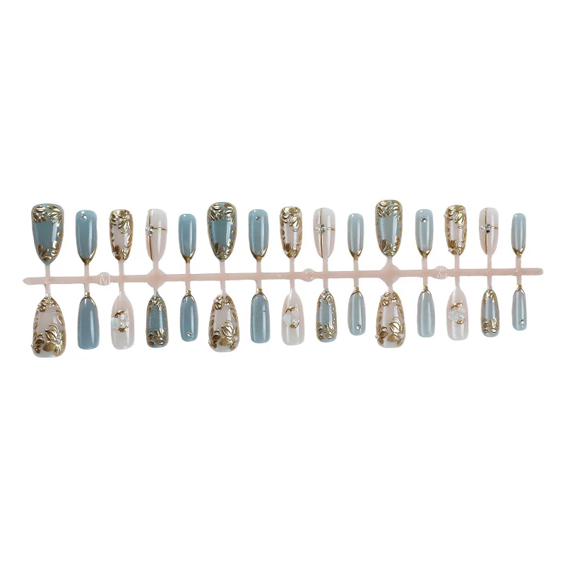Kunstnagelset mit floralen Goldverzierungen Karnz