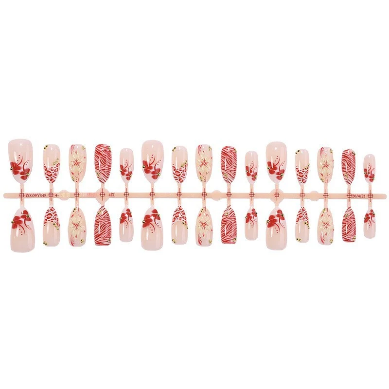 Kunstnagelset mit floralem Design und Goldakzenten Karnz