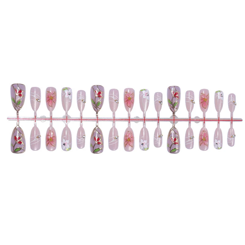 Kunstnagelset mit filigranen floralen Verzierungen und glänzenden Details Karnz