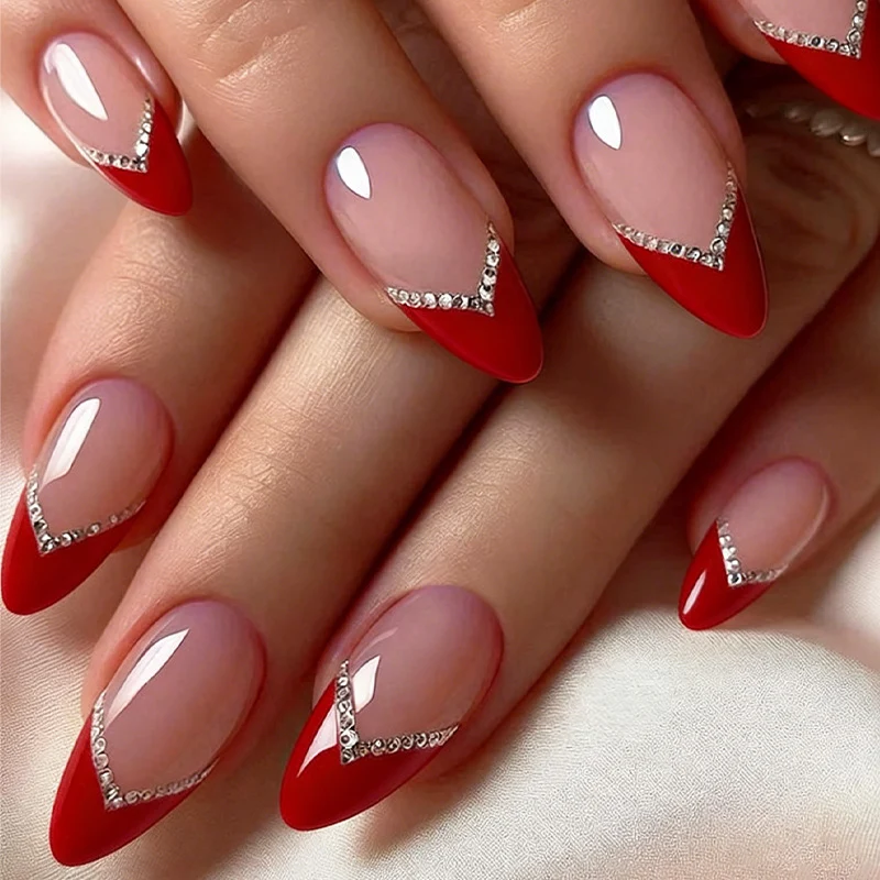 Kunstnagelset mit eleganten roten Akzenten und Strassverzierungen Karnz